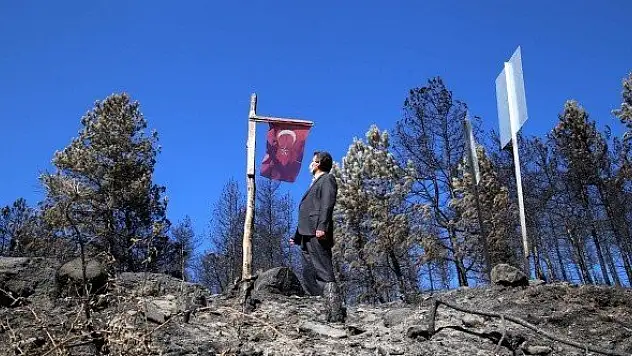 Yanmadan bulunan Türk bayrağını gençler yerine dikti