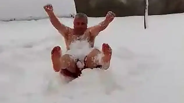 Soğuğa aldırış etmeden soyunup karın içinde yuvarlandı