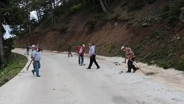 Yeni yapılan yol zarar görmesin diye kürek ve süpürgeyle temizleniyor