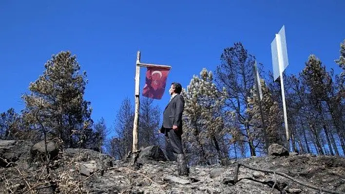 Yanmadan bulunan Türk bayrağını gençler yerine dikti